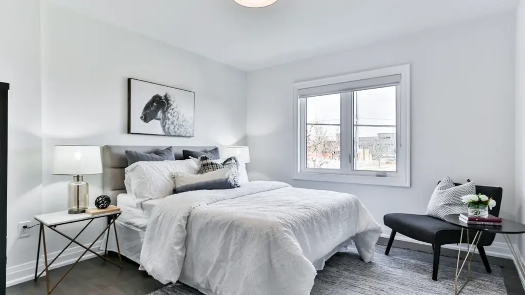 Modern bedroom with neatly made bed, soft pillows, and calm minimalist aesthetic