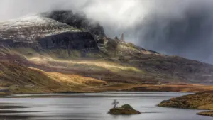Aerial view of a dramatic Scottish highland landscape with heavy storm clouds gathering.